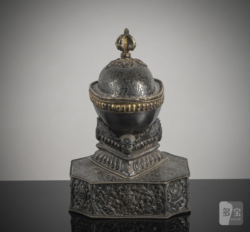 AN EMBOSSED PARCEL GILT SILVER KAPALA ON STAND